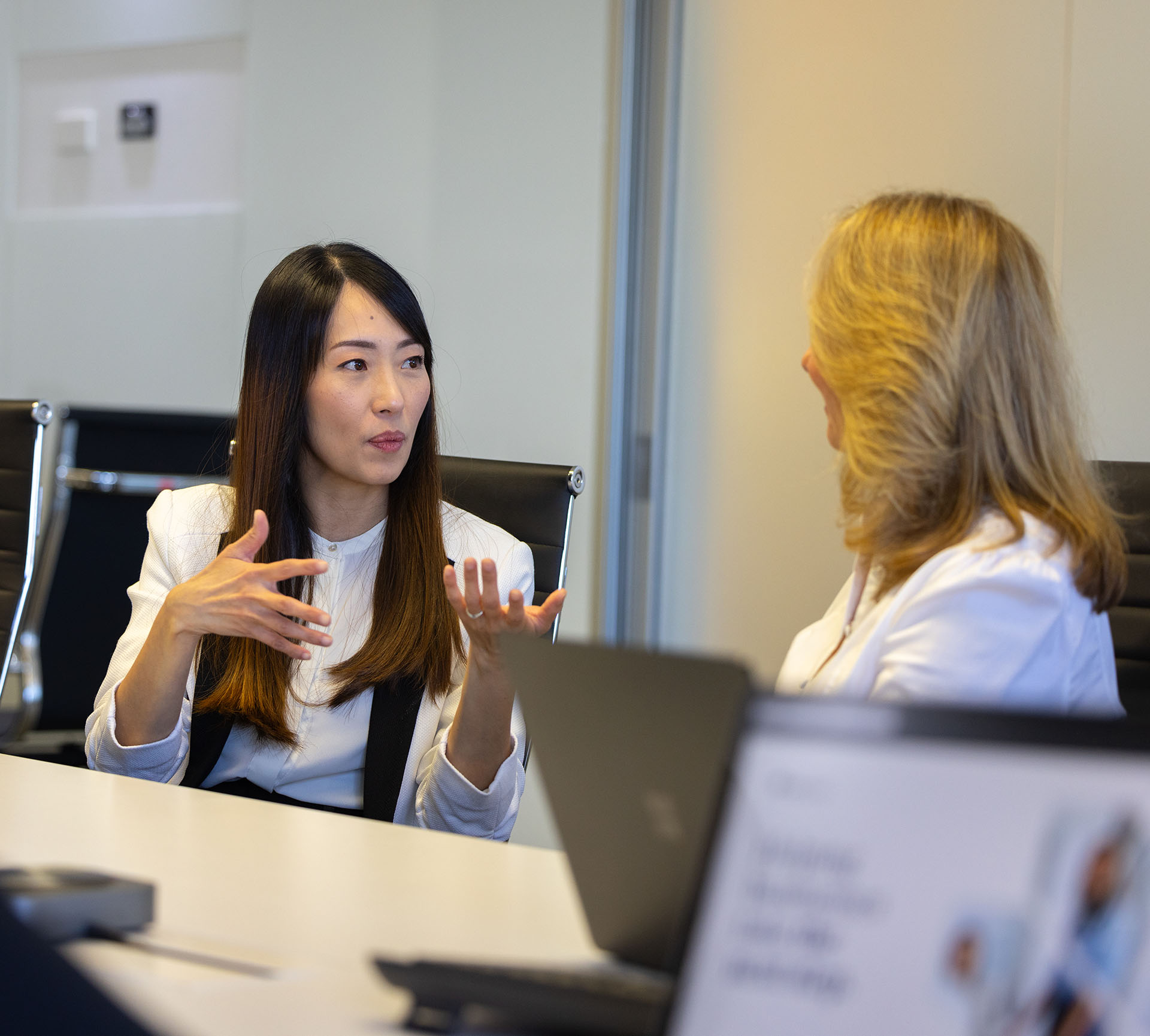 2 ladies having a discussion in an office environment