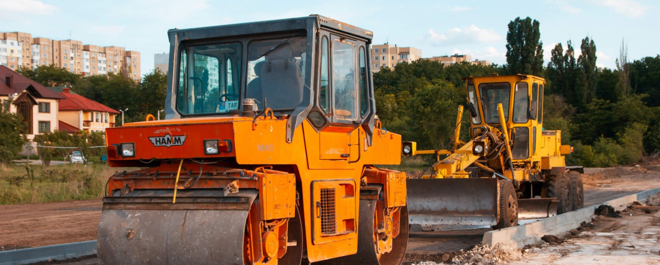 Large construction vehicles laying the foundations for a road